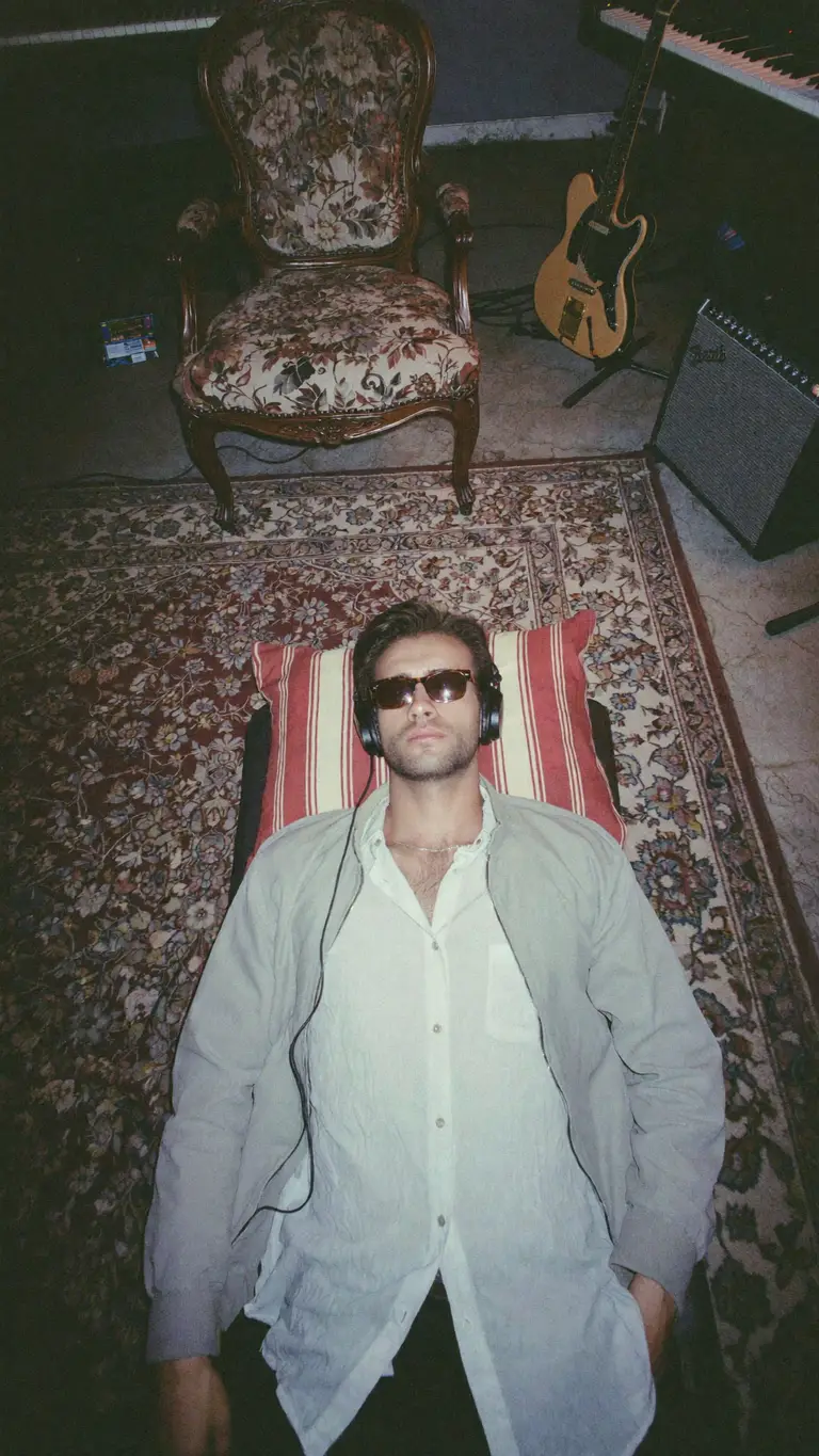 KAIRO VOSS — editorial portrait, headphones on, vintage rug interior
