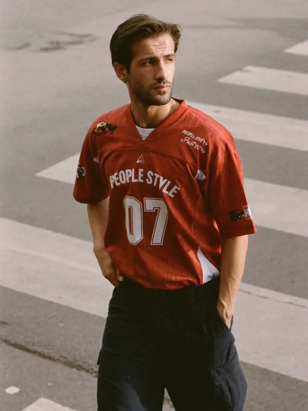 KAIRO VOSS in red 'PEOPLE STYLE 07' jersey crossing a city street — editorial fashion shot